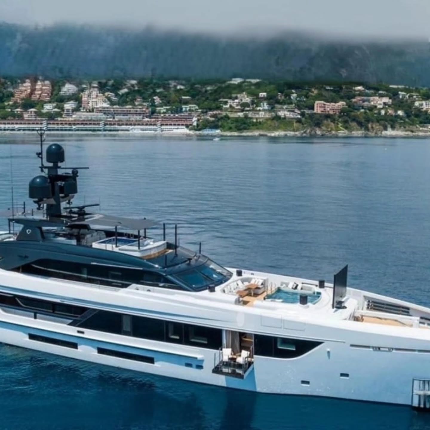 Large private yacht anchored near a coastal destination