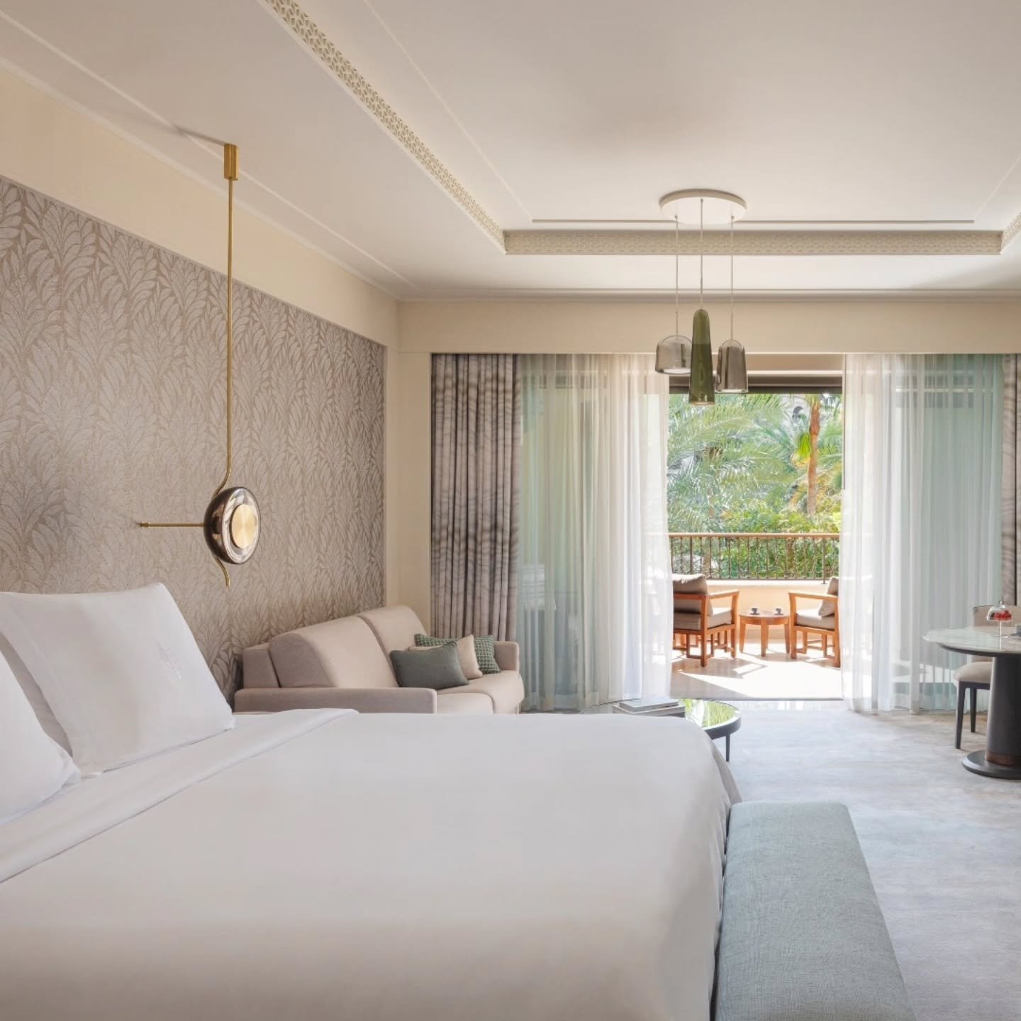 Bright luxury bedroom suite with balcony and soft neutral interiors